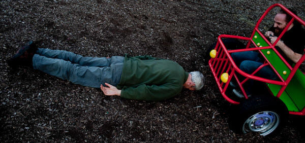 Individual planking on the road as a Jeep approaches